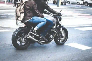 a biker with passenger on back side