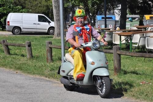Clown rides a moped
