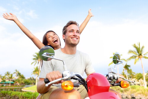 couple having fun while riding on a moped