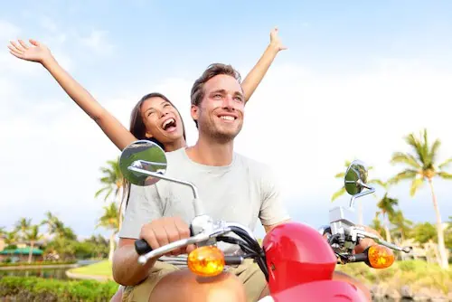 couple having fun while riding on a moped