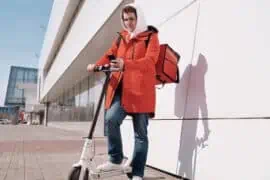 Do You Need to Insure Your Electric Scooter? Man rides a white e-scooter