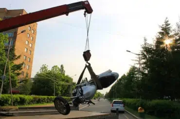 Expected Charges Per Mile When you Take a Motorcycle Towing Service broken bike on road being cleared out