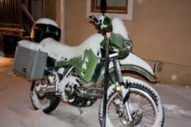 Can a Motorcycle Stay Outside in the Winter? a bike parked outside under snow