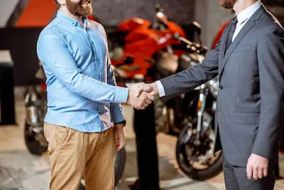 salesperson and customer handshaking in showrooom