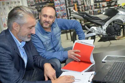 buyer signs on contract paper when buying a motorcycle