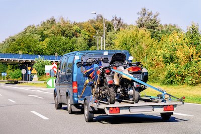 A mini van and motorcycle trailer on road