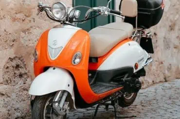 Do I Need a Driver’s License or Motorcycle Endorsement for a 50cc Scooter? classic scooter stands on street