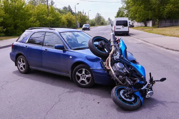 A car and a motorcycle collided on the road.